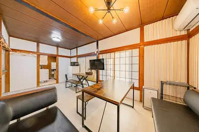 a room with a table and chairs and a television at Soresta INN \u7be0\u5d0e in Tokyo