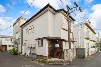 a white house with a door on a street at Soresta INN \u7be0\u5d0e in Tokyo