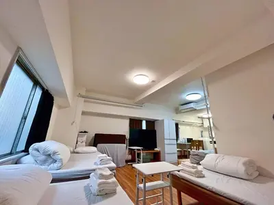 a living room with two beds and a large window at Tokyo\u6674\u7a7a\u5854\u591c\u666fV Skytree\u5730\u9435\u5f92\u6b655\u5206 \u5eda\u623f \u6d17\u8863\u6a5f \u96fb\u68af\u5927\u6a13 \u6a5f\u5834\u76f4\u9054 in Tokyo