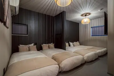 a room with three beds in it with lights at Camo's Tokyo Asakusa in Tokyo