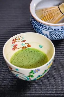 a bowl of green soup with flowers on it at Camo's Tokyo Asakusa in Tokyo