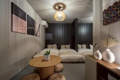 a living room with a bed and a table at Camo's Tokyo Asakusa in Tokyo