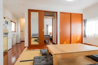 a living room with a table and a bedroom at SYLA HOTEL Akasaka in Tokyo