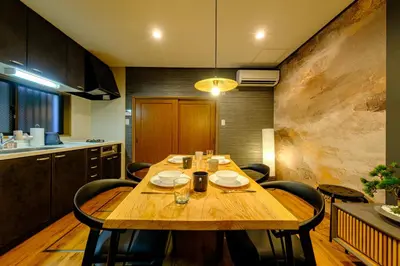 a wooden table in a kitchen with chairs around it at \u30b3\u30af\u30a6 \u6771\u4eac\u90fd\u6e2f\u533a\u829d \u96a0\u308c\u5bb6\u7de8 in Tokyo
