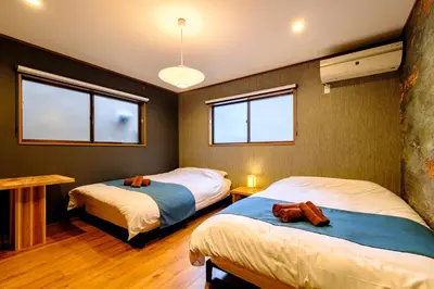 a bedroom with two beds and two windows at \u30b3\u30af\u30a6 \u6771\u4eac\u90fd\u6e2f\u533a\u829d \u96a0\u308c\u5bb6\u7de8 in Tokyo