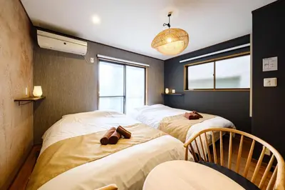 a row of three beds in a room at \u30b3\u30af\u30a6 \u6771\u4eac\u90fd\u6e2f\u533a\u829d \u96a0\u308c\u5bb6\u7de8 in Tokyo