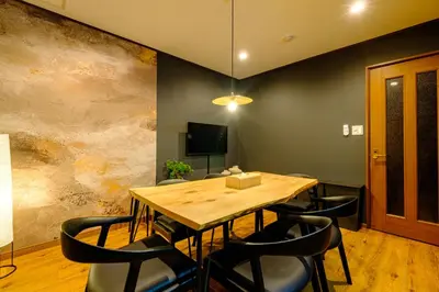 a dining room with a wooden table and chairs at \u30b3\u30af\u30a6 \u6771\u4eac\u90fd\u6e2f\u533a\u829d \u96a0\u308c\u5bb6\u7de8 in Tokyo