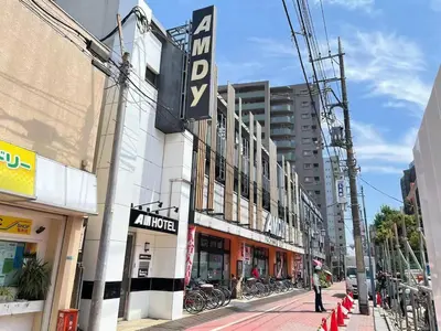a street in a city with a building with a sign at \u30a2\u30e0\u30db\u30fc\u30e0 in Tokyo