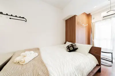 a bedroom with a large bed with a chair and a window at Promotion Asakusa , 1 room, 8 mins to ST Max 2P \u8d85\u9ad8\u6027\u4ef7\u6bd4 \u6d45\u8349\u5168\u65b0\u88c5\u4fee \u8f66\u7ad98\u5206\u949f \u6700\u59272\u4eba in Tokyo