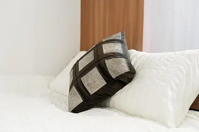 a black and silver pillow sitting on top of a bed at Promotion Asakusa , 1 room, 8 mins to ST Max 2P \u8d85\u9ad8\u6027\u4ef7\u6bd4 \u6d45\u8349\u5168\u65b0\u88c5\u4fee \u8f66\u7ad98\u5206\u949f \u6700\u59272\u4eba in Tokyo
