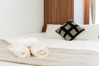 a white bed with towels on top of it at Promotion Asakusa , 1 room, 8 mins to ST Max 2P \u8d85\u9ad8\u6027\u4ef7\u6bd4 \u6d45\u8349\u5168\u65b0\u88c5\u4fee \u8f66\u7ad98\u5206\u949f \u6700\u59272\u4eba in Tokyo