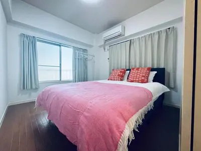 a bedroom with a large bed with red pillows at Kitashinjuku 2DK-2F-B in Tokyo