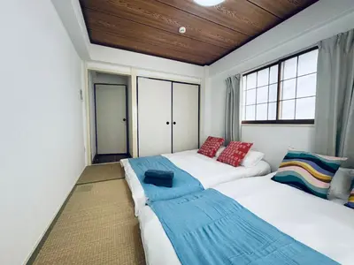 a bedroom with two beds and a window at Kitashinjuku 2DK-2F-B in Tokyo