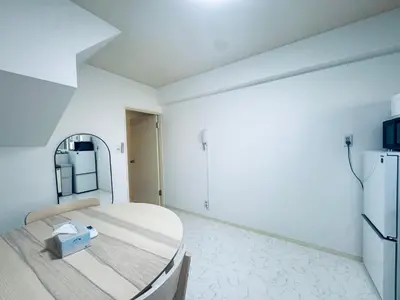 a white room with a bed and a refrigerator at Kitashinjuku 2DK-2F-B in Tokyo