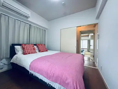 a bedroom with a large bed with red pillows at Kitashinjuku 2DK-2F-B in Tokyo