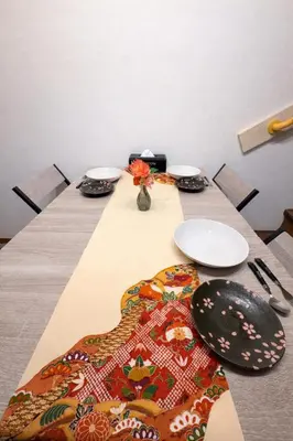 a long table with plates and utensils on it at KENKOU Room -\u5065\u5eb7\u30eb\u30fc\u30e0 \u6771\u4eac\u83ca\u5ddd- in Tokyo