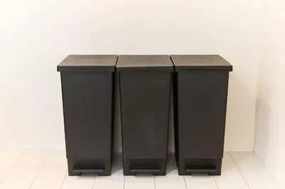 two black trash cans sitting next to a wall at Greenhills Shirokane in Tokyo