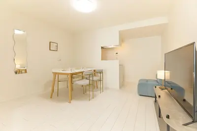 a dining room with a table and chairs and a tv at Greenhills Shirokane in Tokyo
