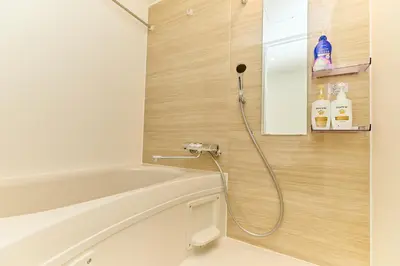 a bathroom with a shower with a white tub at Greenhills Shirokane in Tokyo
