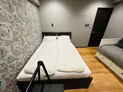 a bed in a room with a wall at Vacances Skytree Plaza in Tokyo