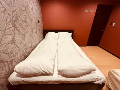 a bed with white sheets and pillows in a room at Vacances Skytree Plaza in Tokyo