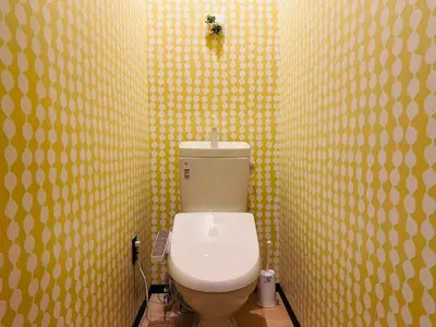 a bathroom with a toilet in a yellow wall at Vacances Skytree Plaza in Tokyo