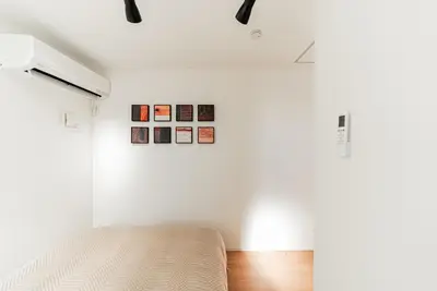 a bedroom with a bed in a room with white walls at Promotion \u6c60\u888b\u522b\u5885 \u5168\u65b03\u5c42\u697c\u72ec\u680b\u522b\u5885 \u5bb6\u7684\u611f\u89c9 3\u5367\u5ba41\u5385Brand new 3-story detached villa with a homey feel 3 rooms \u8fd1\u5546\u5708 \u8bbe\u5907\u9f50\u5168 \u76f4\u8fbe\u65b0\u5bbf \u94f6\u5ea7 \u6d89\u8c37 \u4e0a\u91ce \u8868\u53c2\u9053 \u54c1\u5ddd in Tokyo