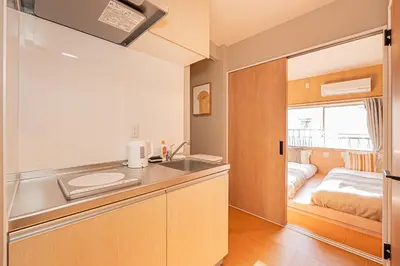 a kitchen with a sink and a bed in a room at Asakusa Miyabi Inn 2F in Tokyo