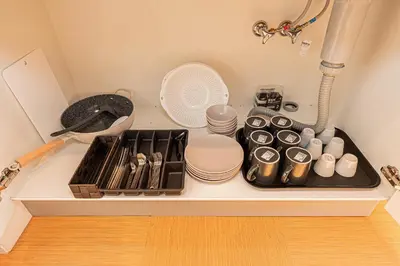 a kitchen counter with a tray of dishes and a fan at Asakusa Miyabi Inn 2F in Tokyo