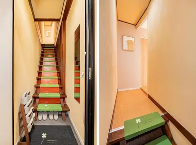 a hallway with stairs leading up to a room with green tables at Asakusa Miyabi Inn 2F in Tokyo