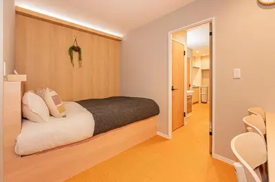 a bedroom with a bed and a hallway with chairs at Asakusa Miyabi Inn 1F in Tokyo