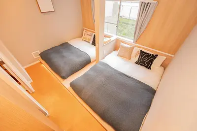 two beds in a small room with a window at Asakusa Miyabi Inn 1F in Tokyo