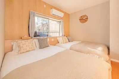 two beds in a small room with a window at Asakusa Miyabi Inn 1F in Tokyo
