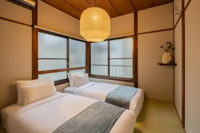 two beds in a room with two windows at HAN'S EBISU Hanare - Shibuya - Entire Renovated House in Tokyo