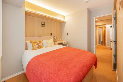 a bedroom with a large bed with an orange blanket at Komorebi Asakusa 202 Cozy 6P Stay The 77 House Tokyo in Tokyo