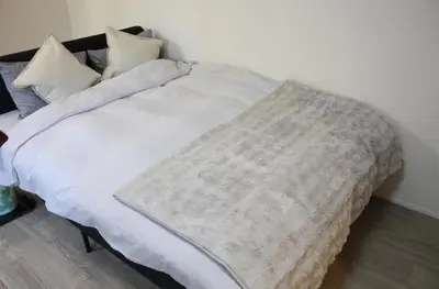 a bed with a blanket on it in a room at Jasnine House in Tokyo