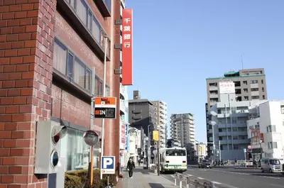 a city street with buildings and a bus at Jasnine House in Tokyo