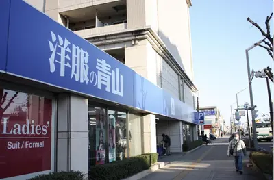 a woman walking down a sidewalk in front of a store at Jasnine House in Tokyo