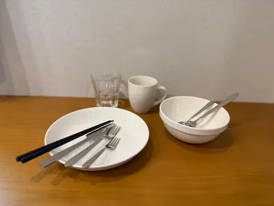 a table with two white plates and utensils on it at PRISM Inn Ikegami Kamata in Tokyo