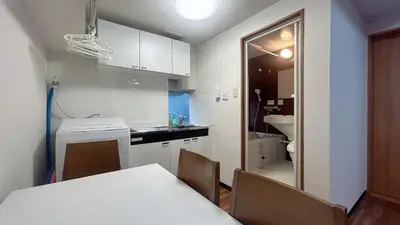 a kitchen with a white table and chairs and a sink at Skytree\u5730\u9435\u5f92\u6b655\u5206 3\u5957\u885b\u6d74 3\u5957\u623f\u9593 \u6d17\u8863\u6a5f \u6709\u96fb\u68af \u9802\u6a13\u6674\u7a7a\u5854\u591c\u666f \u81ea\u52a9\u5165\u4f4f V44 in Tokyo