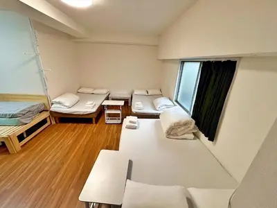 a dorm room with three beds and a window at Skytree\u5730\u9435\u5f92\u6b655\u5206 3\u5957\u885b\u6d74 3\u5957\u623f\u9593 \u6d17\u8863\u6a5f \u6709\u96fb\u68af \u9802\u6a13\u6674\u7a7a\u5854\u591c\u666f \u81ea\u52a9\u5165\u4f4f V44 in Tokyo