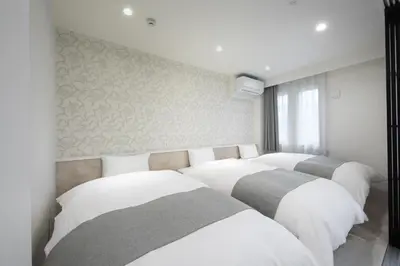 a row of four beds in a room at Hotel Kototoi East in Tokyo