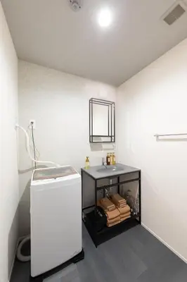 a white bathroom with a sink and a mirror at Hotel Kototoi East in Tokyo