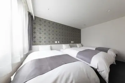 two beds in a room with white walls at Hotel Kototoi East in Tokyo