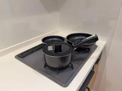 two pans sitting on a stove in a kitchen at \u8535 The KURA in Urayasu