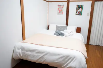 a bedroom with a large white bed with towels on it at Asakusa Hub Stay in Tokyo