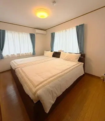 a bedroom with a large bed with blue curtains at Hotel Hanamichi in Tokyo