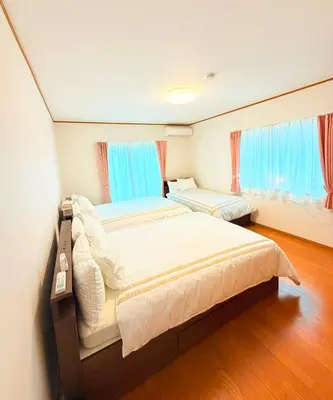 a bedroom with a large bed and two windows at Hotel Hanamichi in Tokyo