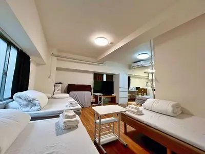 a room with three beds and a living room at Tokyo\u6674\u7a7a\u5854\u591c\u666f 3\u5957\u885b\u6d74 Skytree\u5730\u9435\u5f92\u6b655\u5206 \u81ea\u52a9\u5165\u4f4f \u5eda\u623f \u6d17\u8863\u6a5f \u96fb\u68af \u6d74\u7f38VD4 in Tokyo