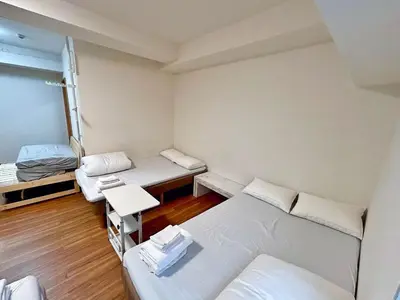 a small room with three beds and a table at Skytree\u5730\u9435\u5f92\u6b655\u5206 4\u5957\u885b\u6d74 4\u9593\u623f \u6a5f\u5834\u8fea\u58eb\u5c3c\u76f4\u9054 \u5eda\u623f\u6d17\u8863\u6a5f \u6d74\u7f38 \u9802\u6a13\u6771\u4eac\u591c\u666fVD44 in Tokyo
